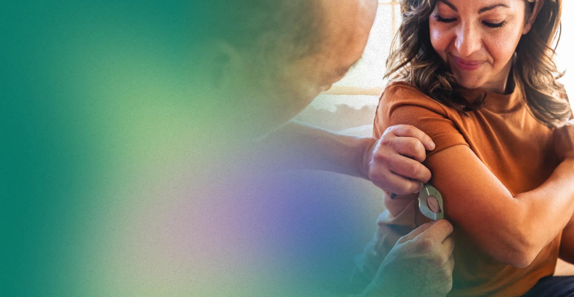 A woman with diabetes getting fitted with a CGM. She received the connected device for better diabetes management as part of her virtual chronic care program.