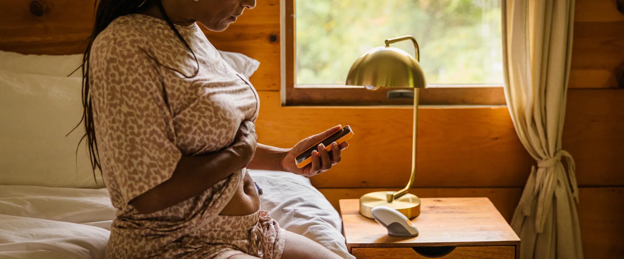  Image of a woman checking her CGM device and blood sugar levels.
