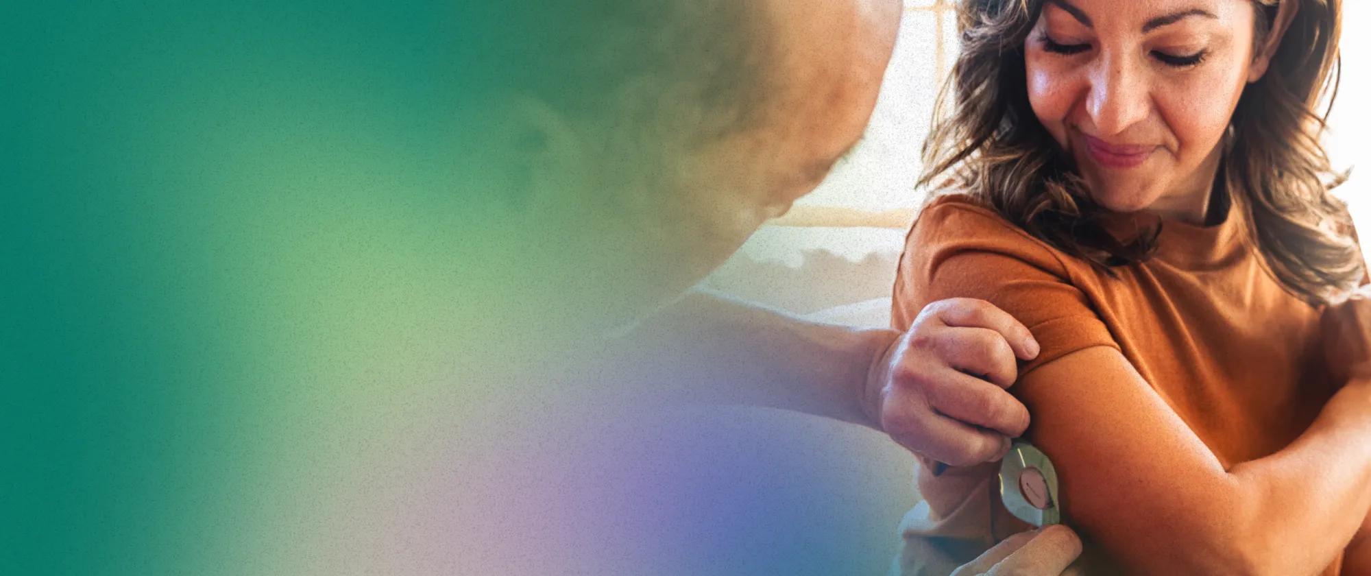 A woman with diabetes getting fitted with a CGM. She received the connected device for better diabetes management as part of her virtual chronic care program.