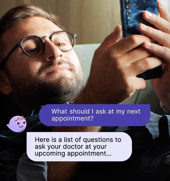 A man lies on the couch holding a phone. His messages with Violet about what to ask at his next doctor appointment overlay at the bottom.