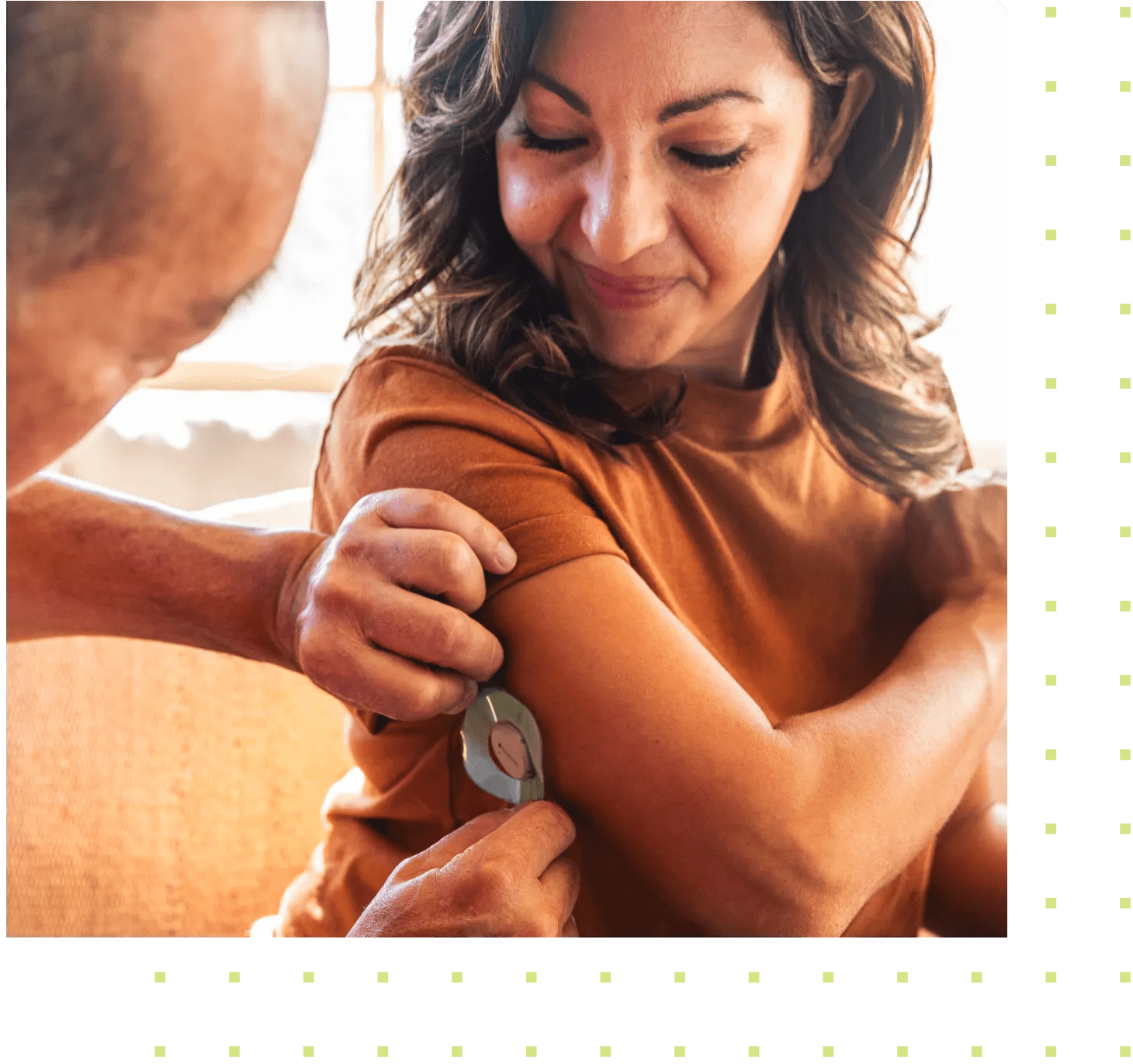 A hispanic-descent woman with diabetes getting fitted with a CGM. She received the connected device for better diabetes management as part of her virtual care program