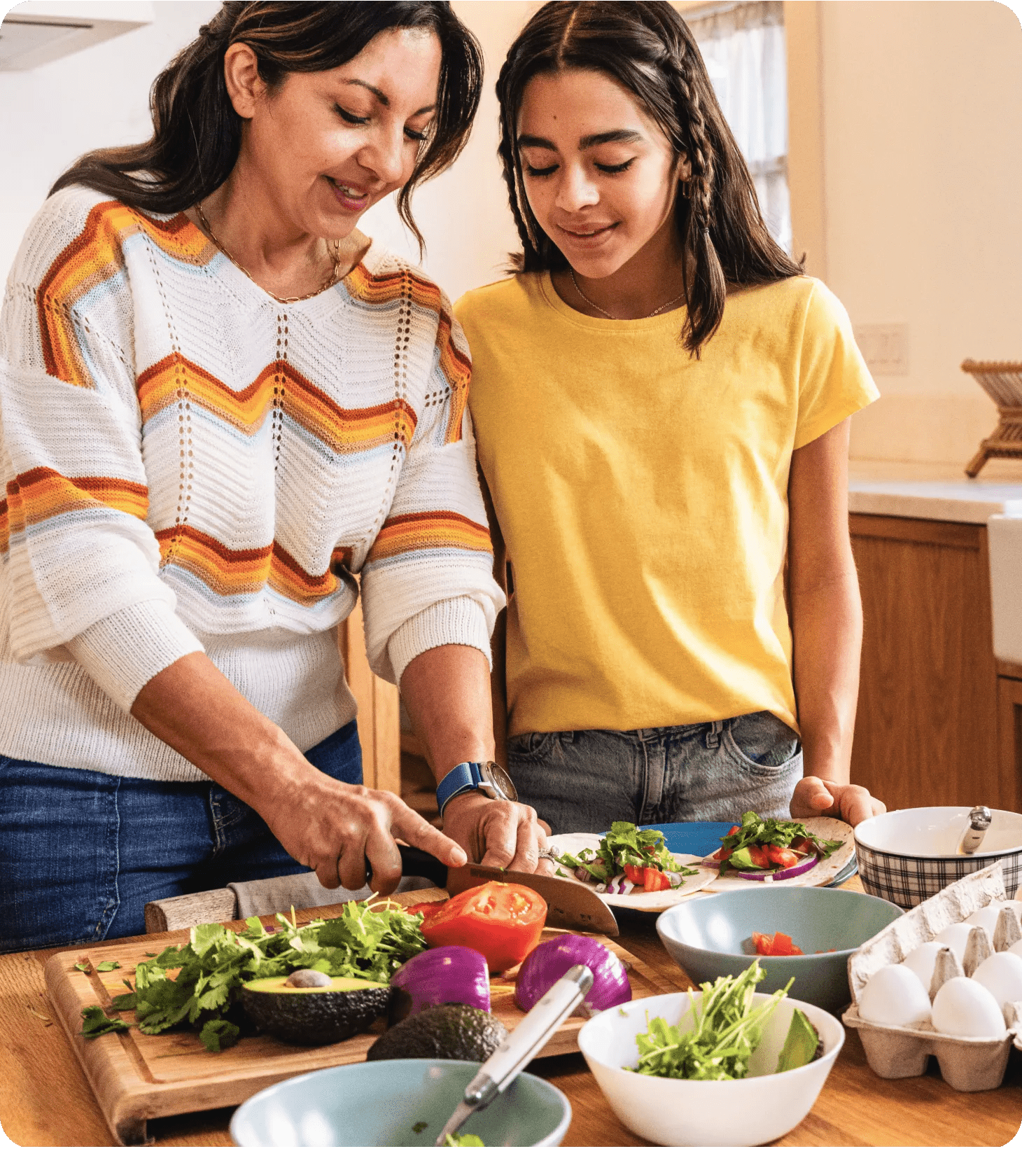 A Hispanic-descent, middle-aged woman with her pre-teen daughter in their kitchen making a healthy brunch recipe.